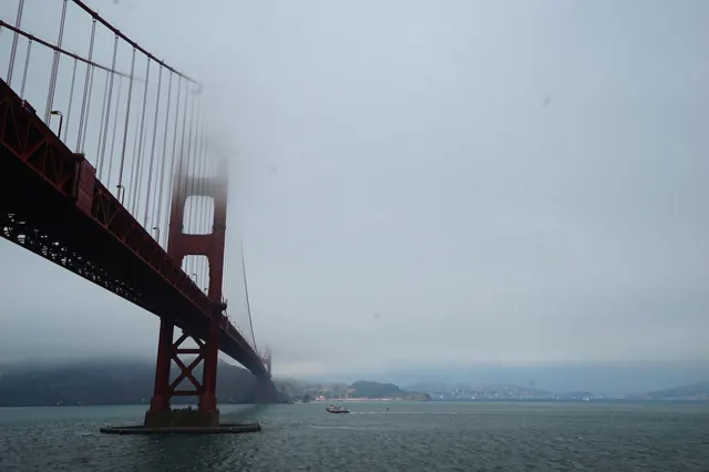 Looking up at the Golden Gate Bridge disappearing into fog