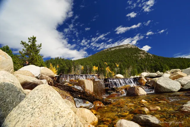 A rocky mountain stream under a blue sky