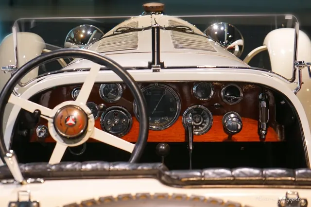 The wooden dashboard and steering wheel of a classic car