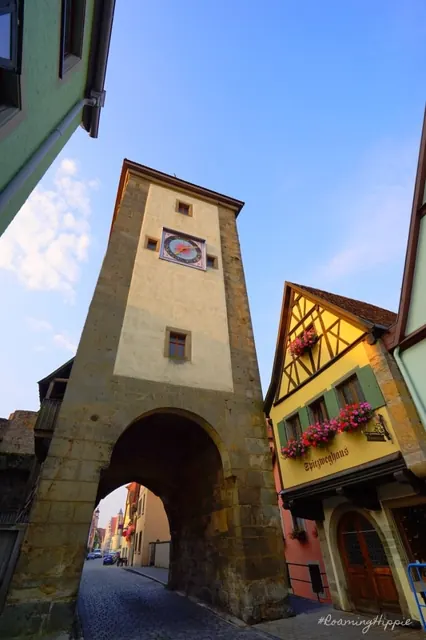 A gate tower arch beside a yellow half-timbered house