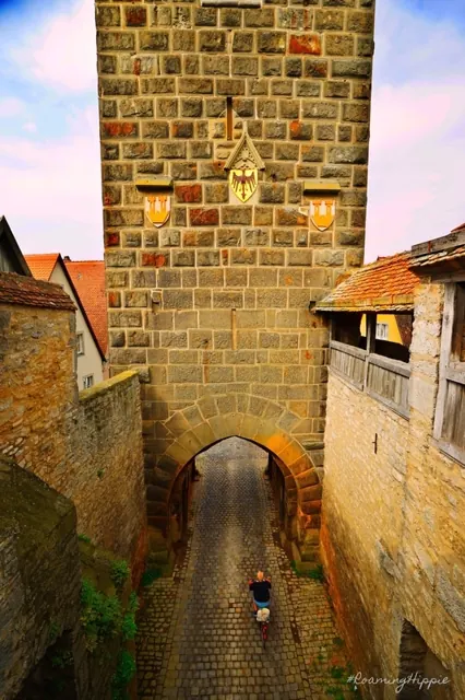 A stone gate tower over a narrow cobbled lane