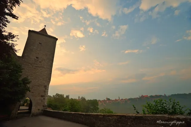 A stone tower overlooking a valley at sunset