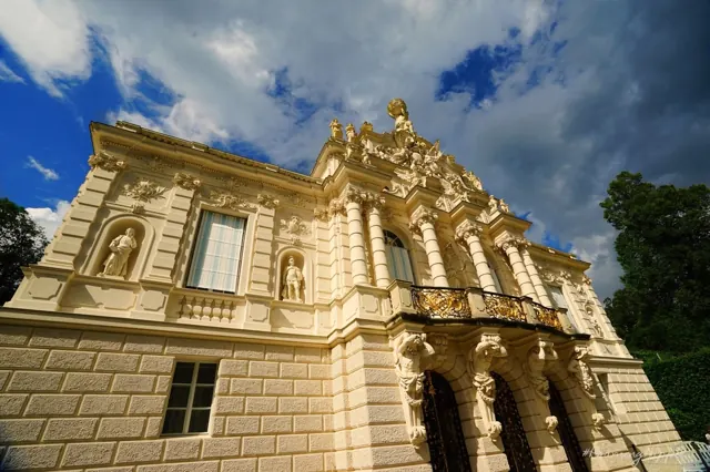 The ornate cream facade of a palace under blue sky