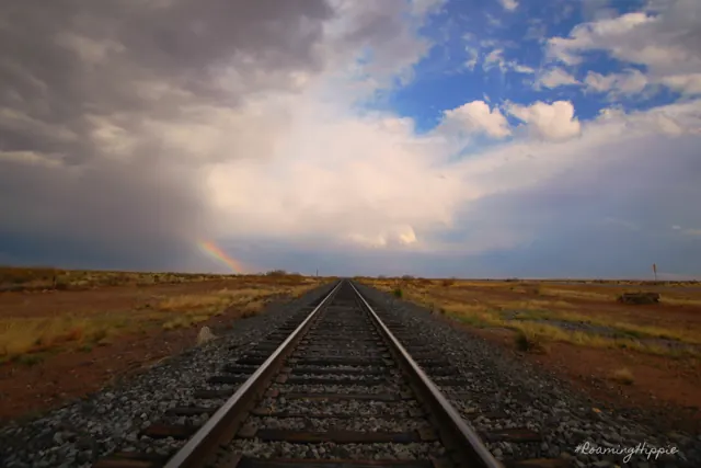 Railroad tracks running straight into the distance under a cloudy sky